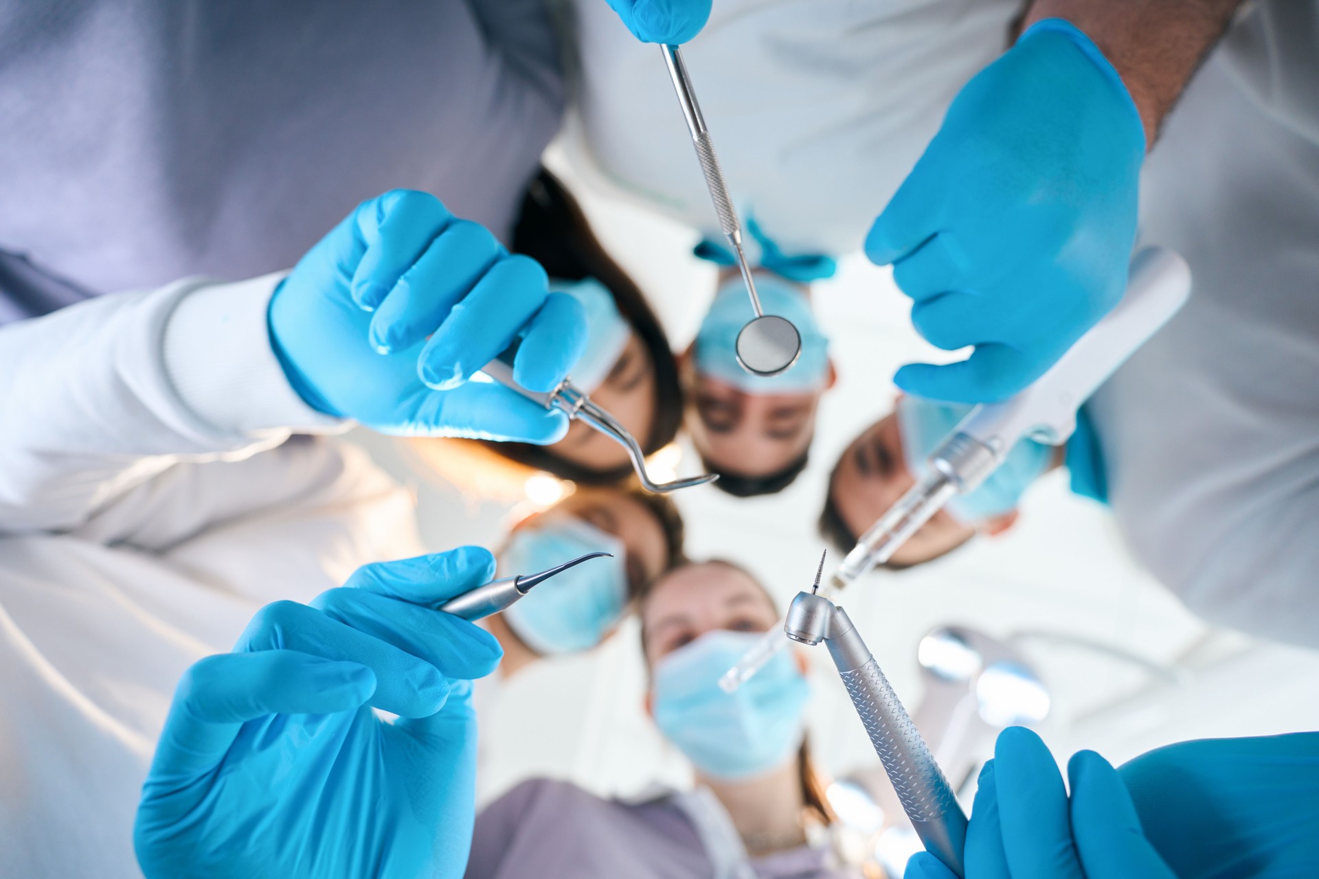 Five dentists with special tools in their hands